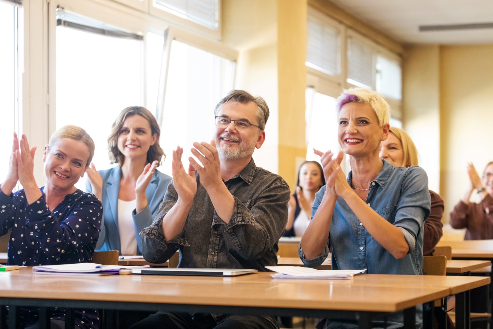 Gelukkige deelnemers applaudisseren tijdens een In2Learning bedrijfstraining
